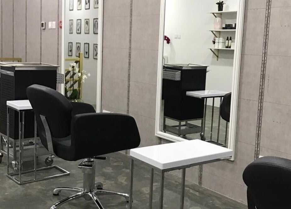 Modern interior of Color Cravings Beauty Salon in Bu Quwah, Northern Governorate, BH, showcasing sleek styling stations.