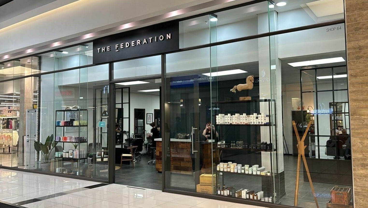 Exterior view of The Federation Kyalami in Midrand, Gauteng, ZA showcasing modern glass storefront design.