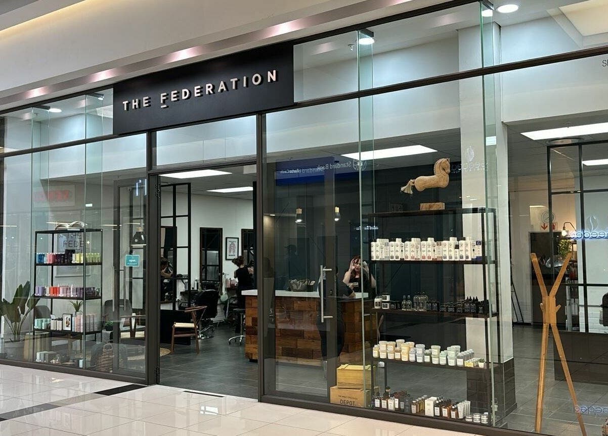 Exterior view of The Federation Kyalami in Midrand, Gauteng, ZA showcasing modern glass storefront design.