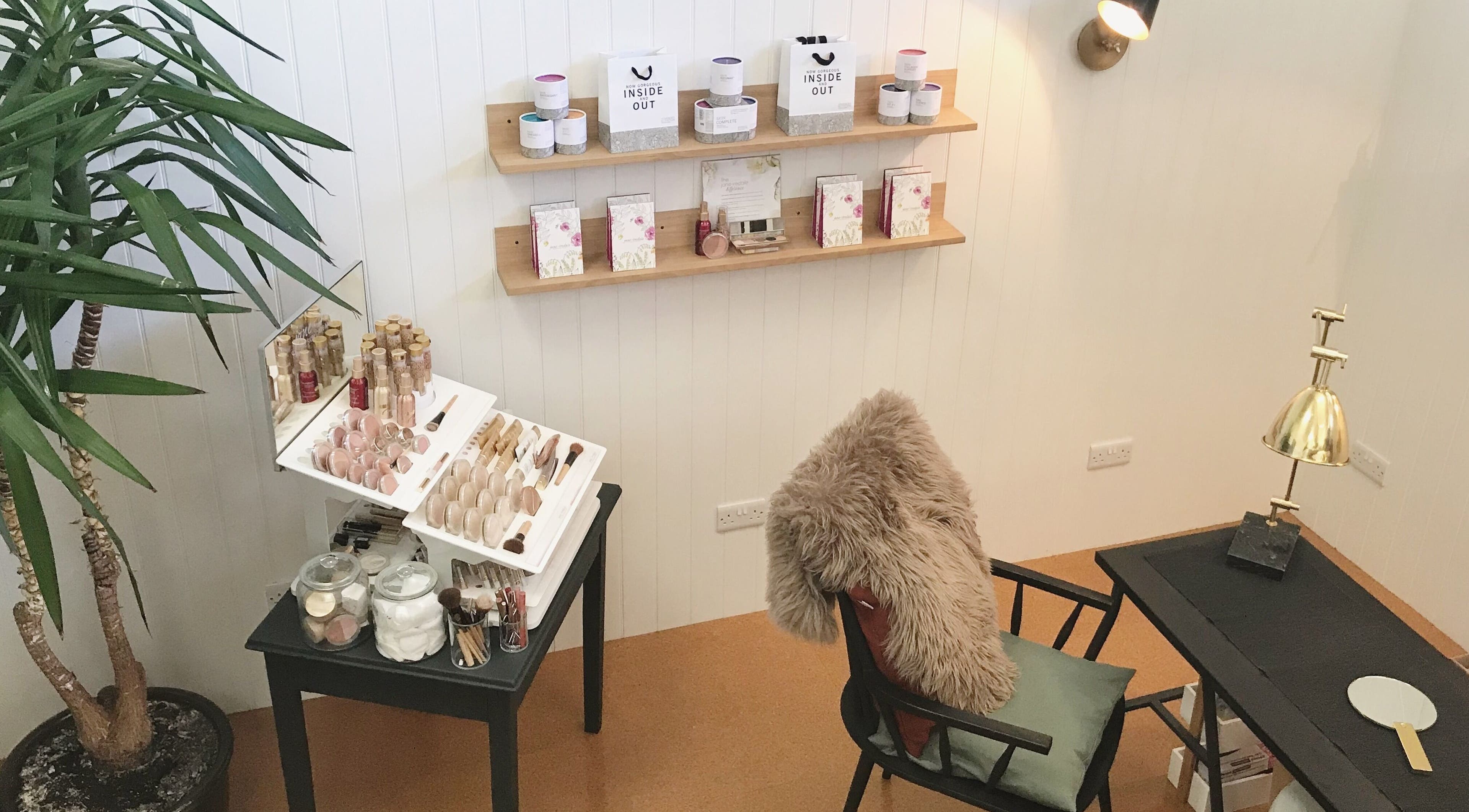 Stylish beauty setup at Mowhay, Chilcompton, England, GB with cosmetics displayed on shelves and table.