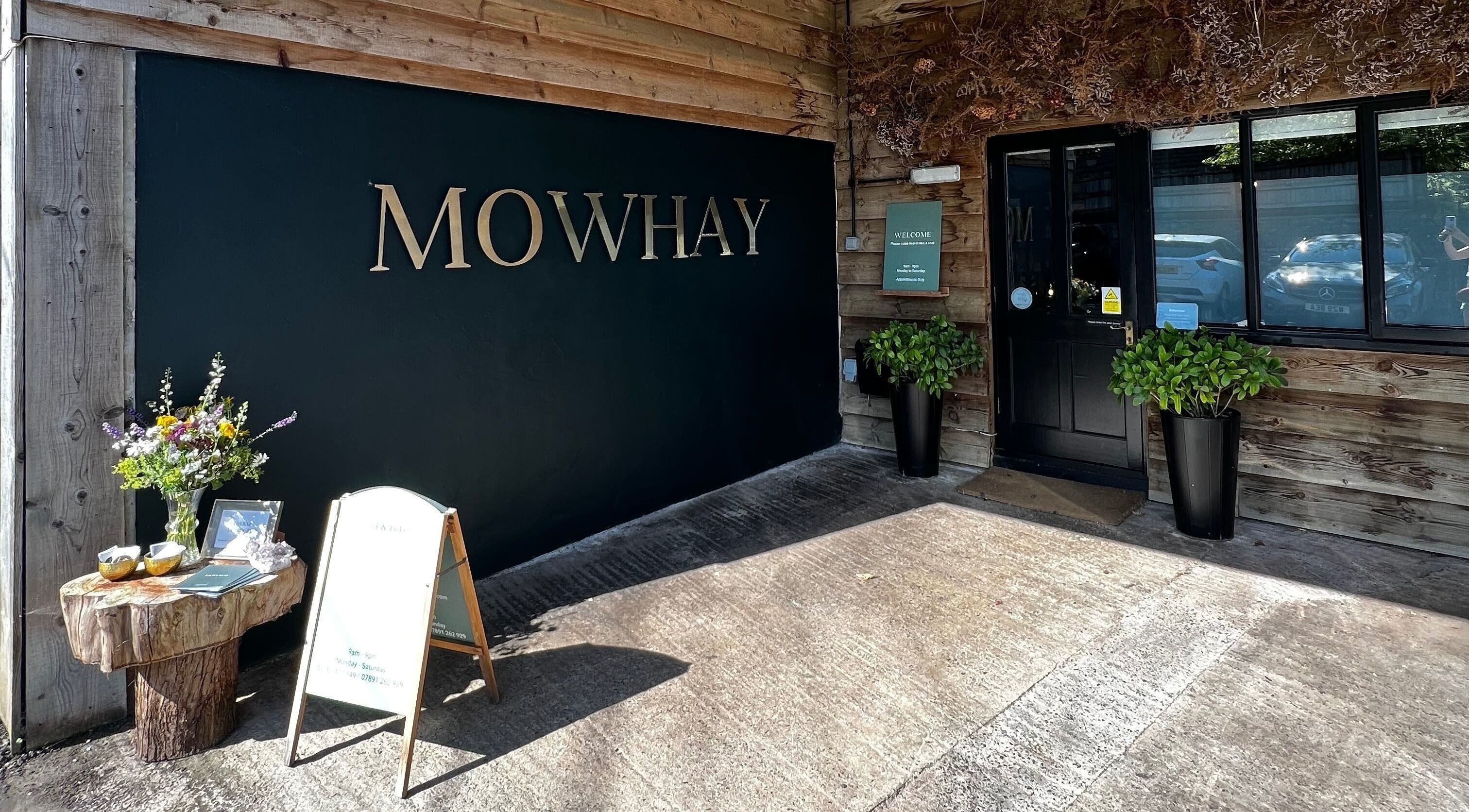 Entrance to Mowhay in Chilcompton, England, featuring rustic wood design and vibrant flowers.