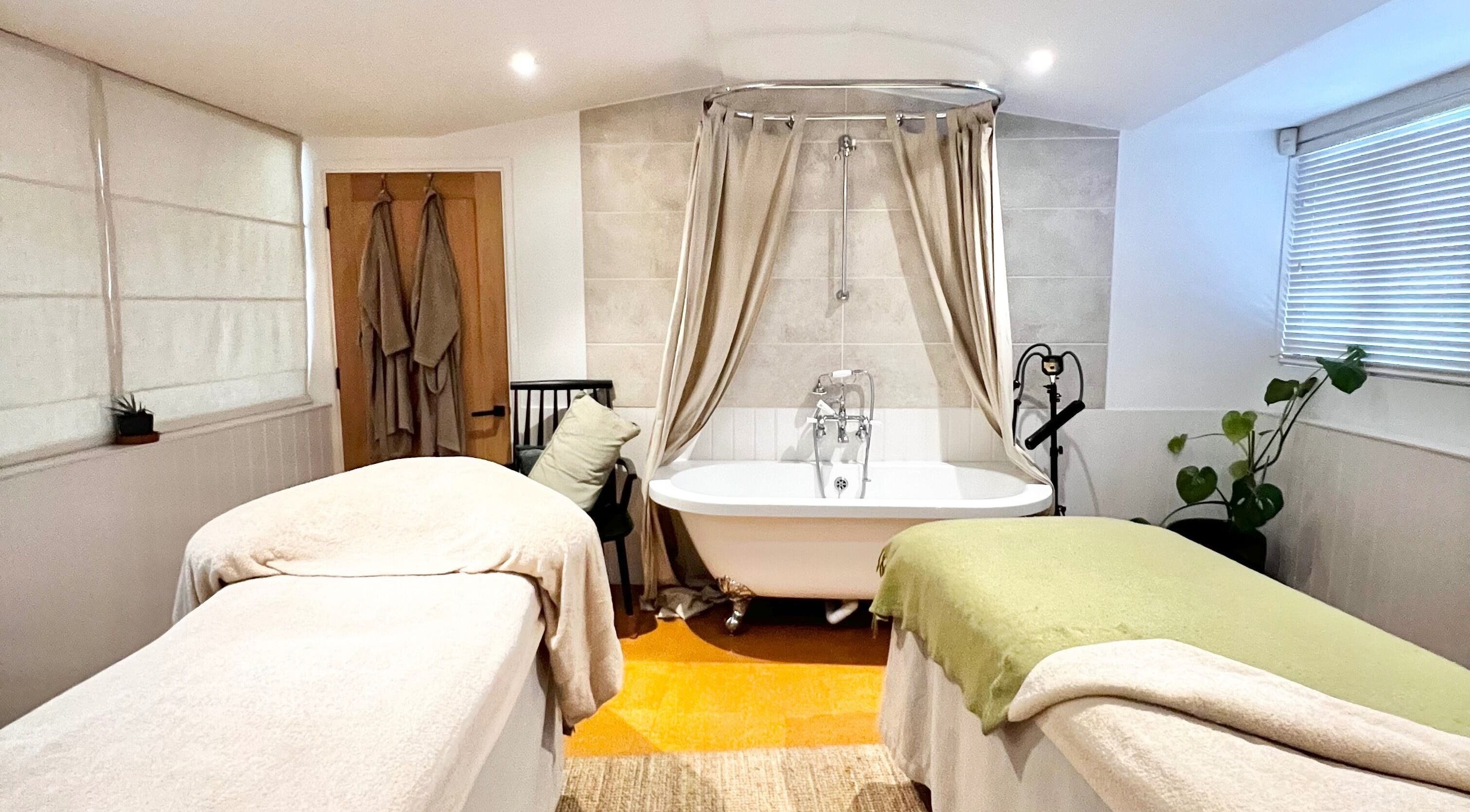 Luxurious spa room at Mowhay, Chilcompton, England, GB with massage tables and a vintage bathtub.