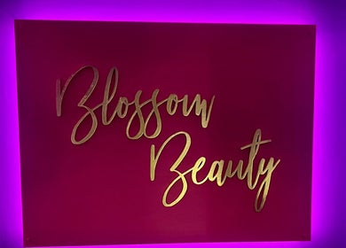 Vibrant Blossom Beauty sign in Abbeyleix, County Laois, IE, illuminated with neon purple lights.