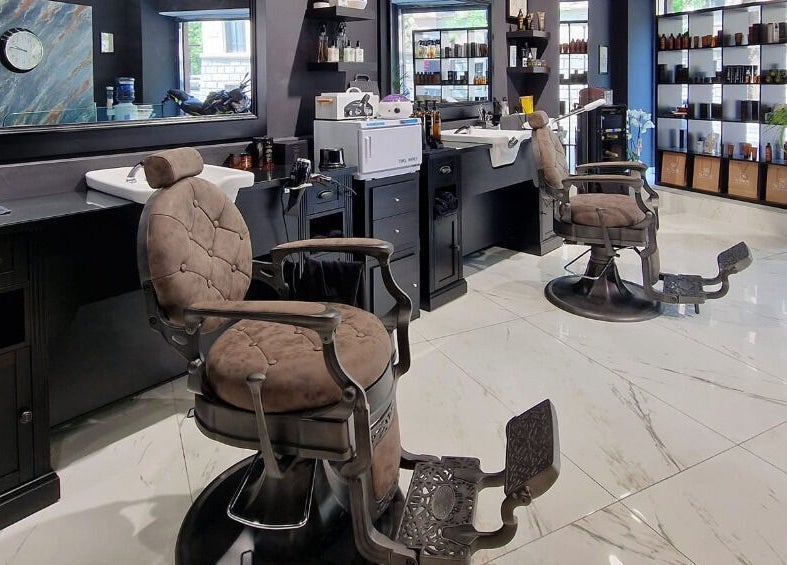 Interno elegante di Barber Lounge, Milano, con poltrone moderne e arredamento raffinato.