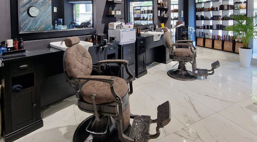 Interno elegante di Barber Lounge, Milano, con poltrone moderne e arredamento raffinato.
