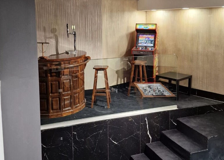Interno accogliente del Barber Lounge, Milano, Lombardia, IT con angolo giochi e bar in legno.