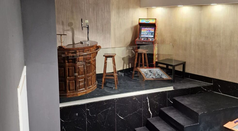 Interno accogliente del Barber Lounge, Milano, Lombardia, IT con angolo giochi e bar in legno.