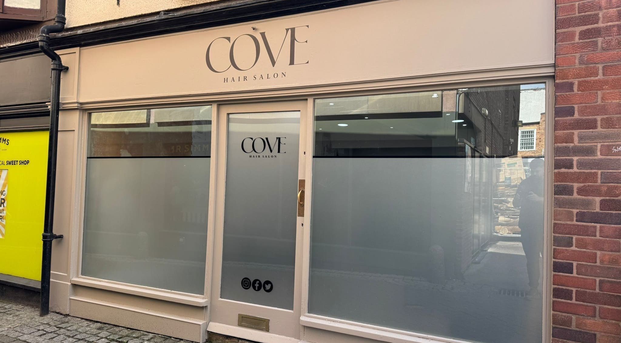 Front view of Cove Hair Salon in Stafford, England featuring minimalist design and large windows.