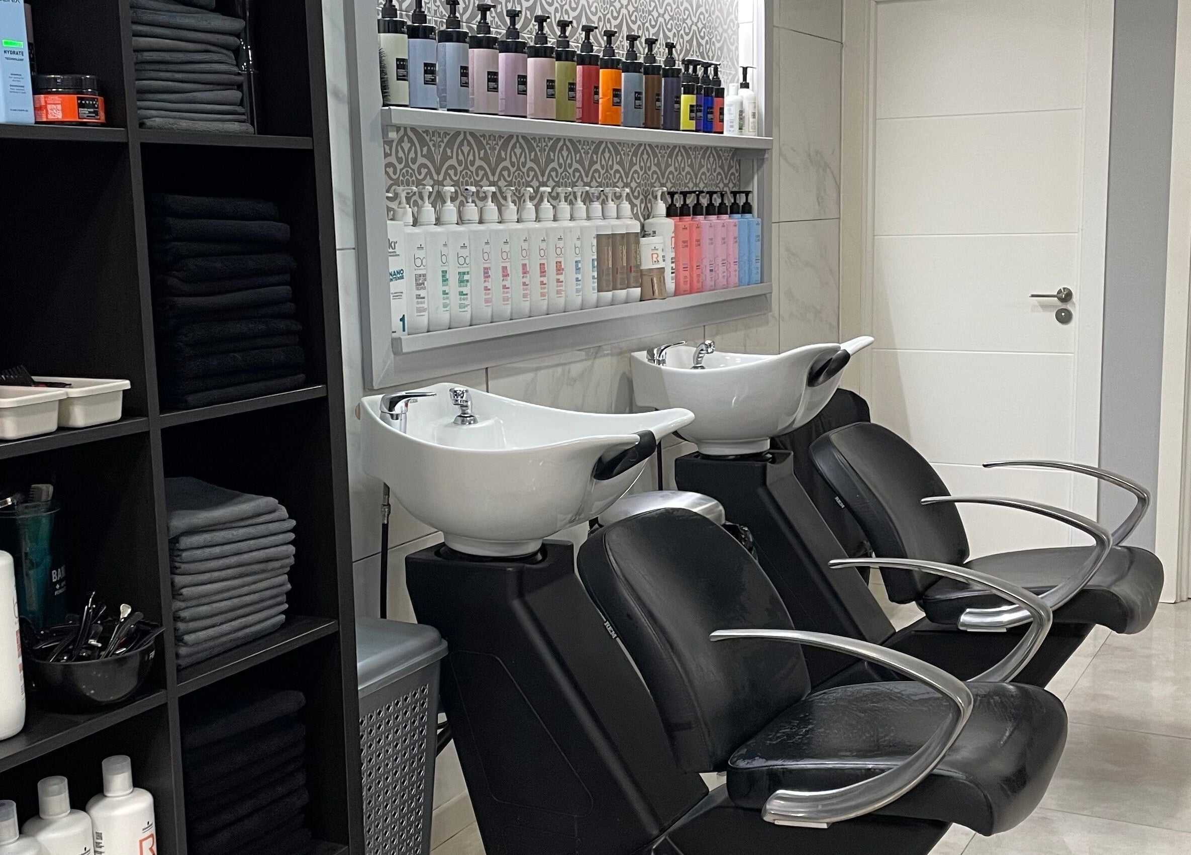 Modern wash stations at Gemini Salon in Calvià, Illes Balears, ES, featuring sleek design and products.