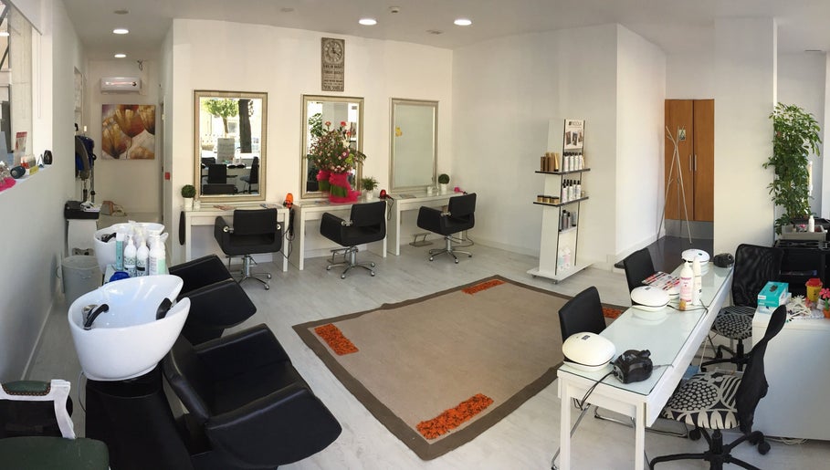 Interior elegante do Atena Hair Style & Spa em Porto, PT, com estações de beleza modernas e decorativas.