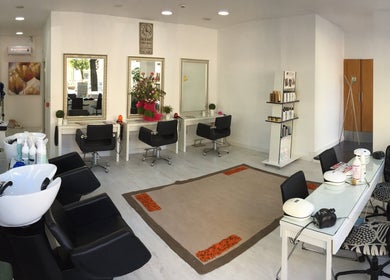 Interior elegante do Atena Hair Style & Spa em Porto, PT, com estações de beleza modernas e decorativas.