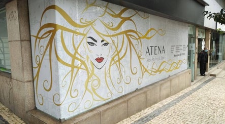 Entrada da Atena Hair Style & Spa em Porto, Porto, PT, com ilustração artística vibrante na vitrine.