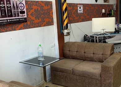 Sala de espera en Clandestine Barber Shopvip001, San Vicente, San José, CR. Sofá cómodo y moderno.