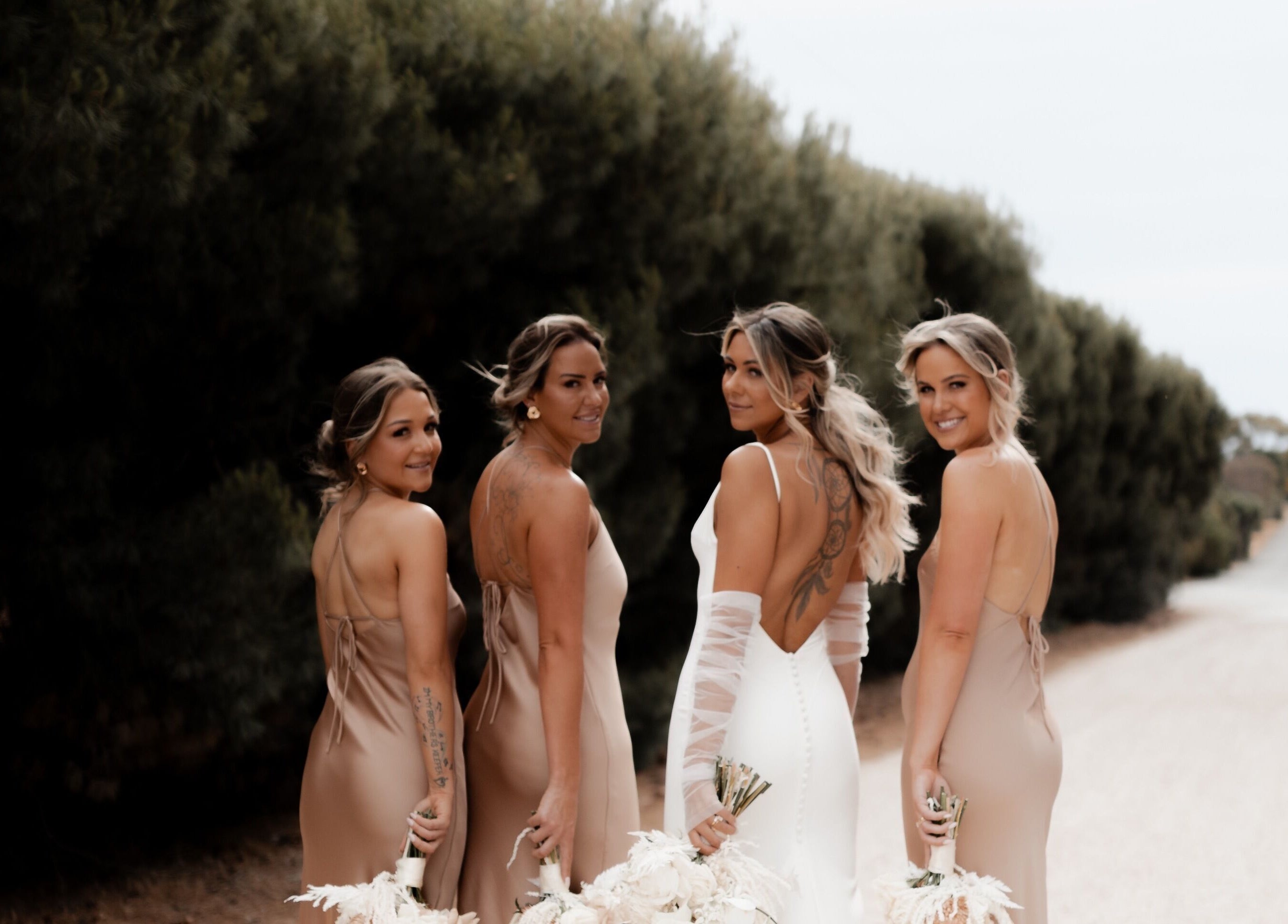 Bridal party with glowing tans from The Afterglow Spray Tans, Greenwith, South Australia, AU posing outdoors.