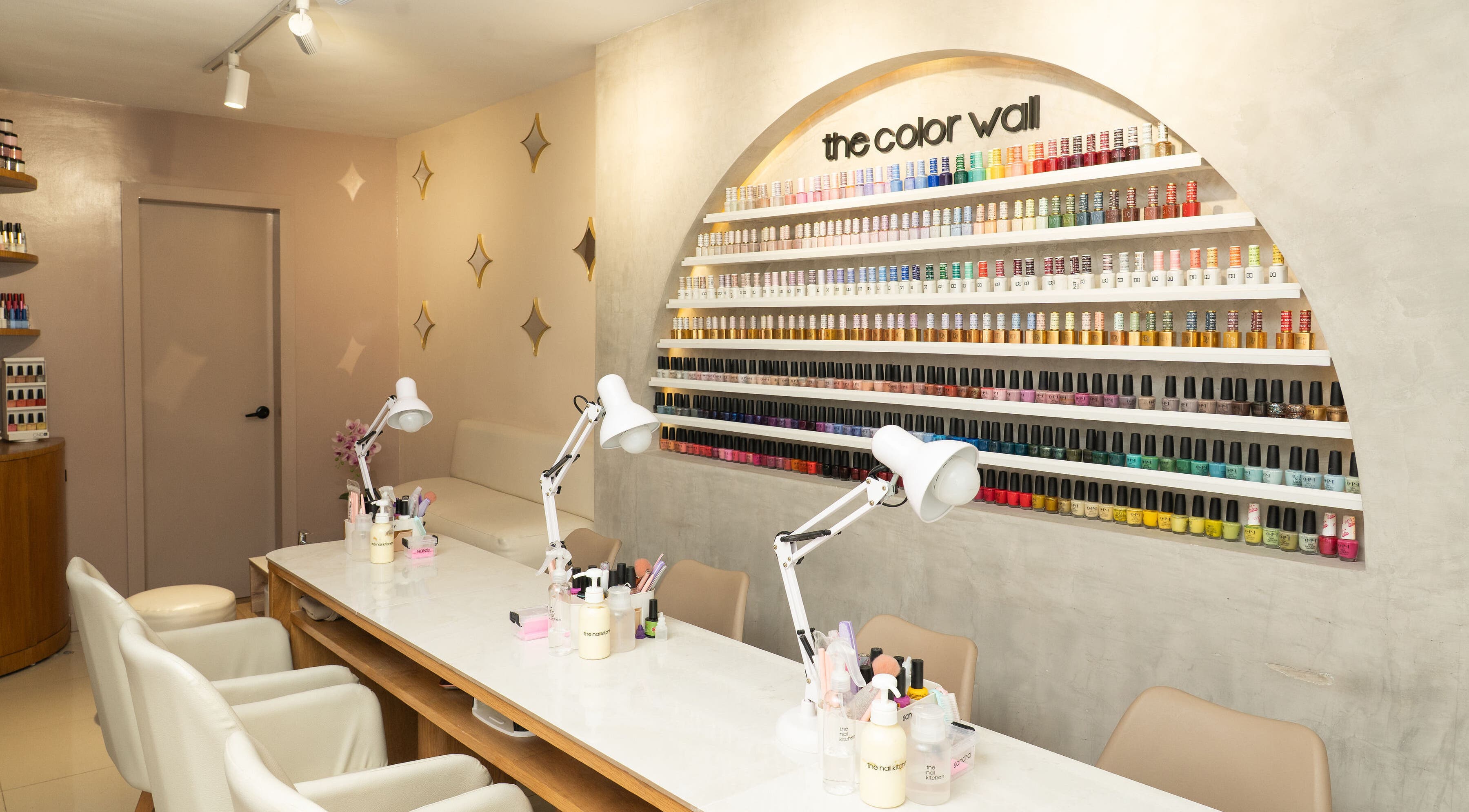 The Nail Kitchen Urdesa en Guayaquil, Guayas, EC presenta una pared de esmaltes vibrantes en un entorno elegante.