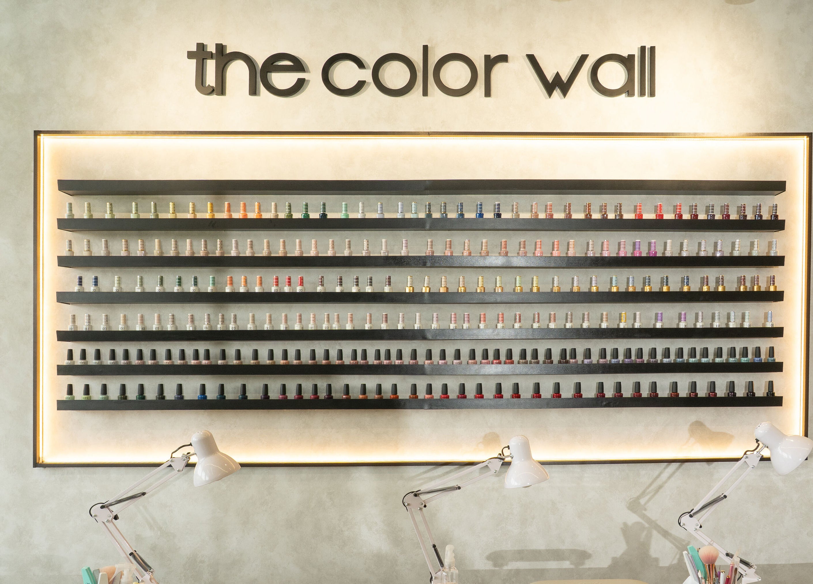 Estante de esmaltes en The Nail Kitchen Villa Club, Daule, Guayas, EC, mostrando variedad de colores vibrantes.
