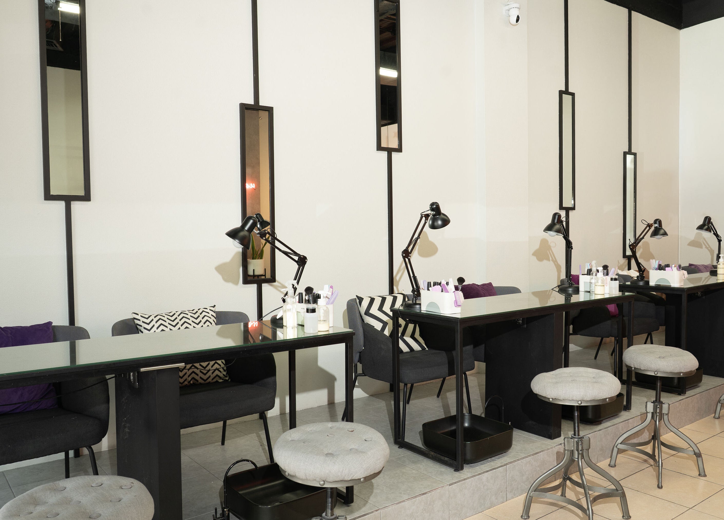 Mesa de manicura en The Nail Kitchen Samborondón, Guayas, EC con sillas elegantes y decoración moderna.