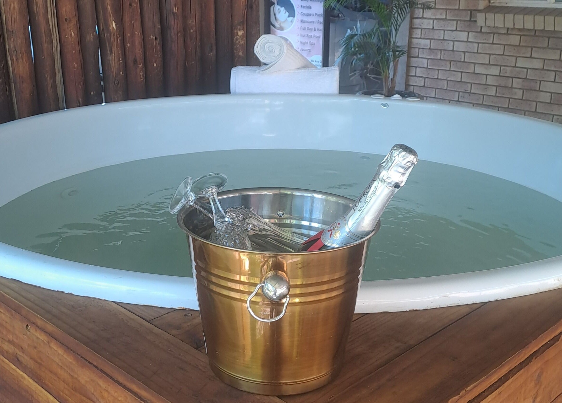 Relax in the luxury hot tub at Zoella Day Spa, Bela-Bela, Limpopo with a champagne bucket beside.