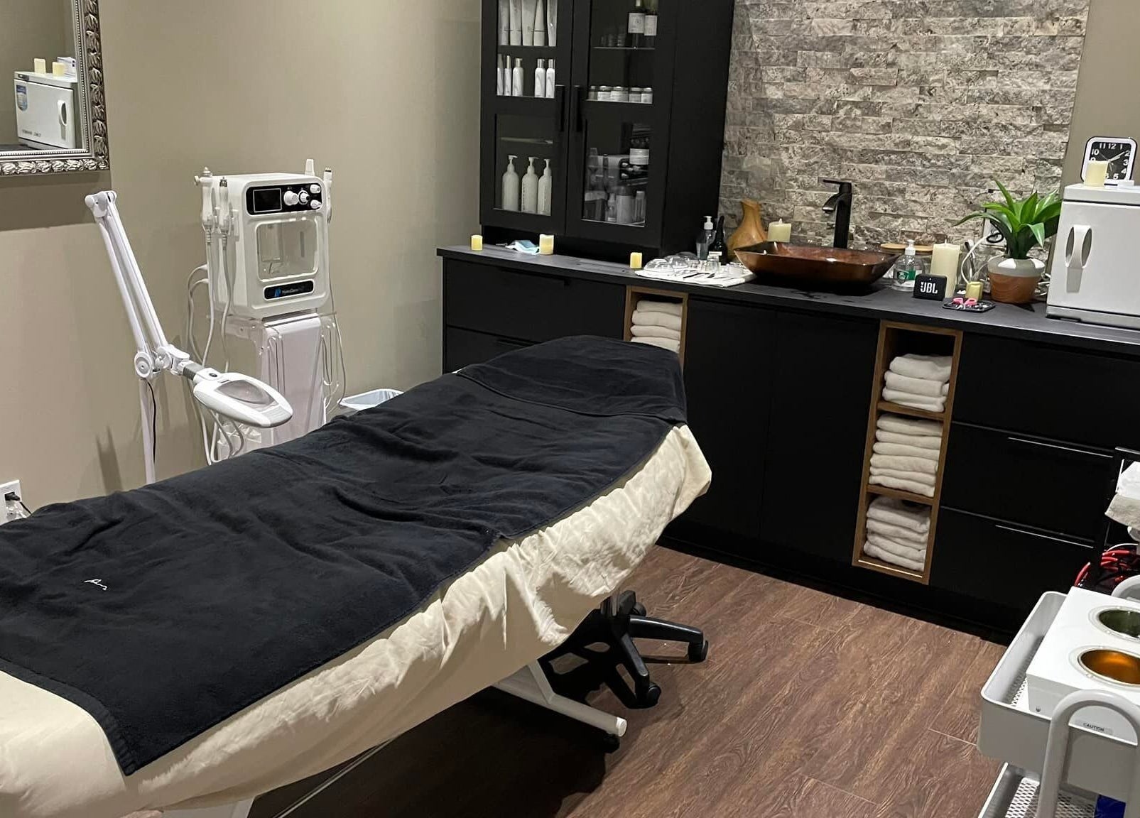 Treatment room at Nurse Cori Injectables & Aesthetics in Milton, Ontario, CA, featuring a massage bed and aesthetic tools.