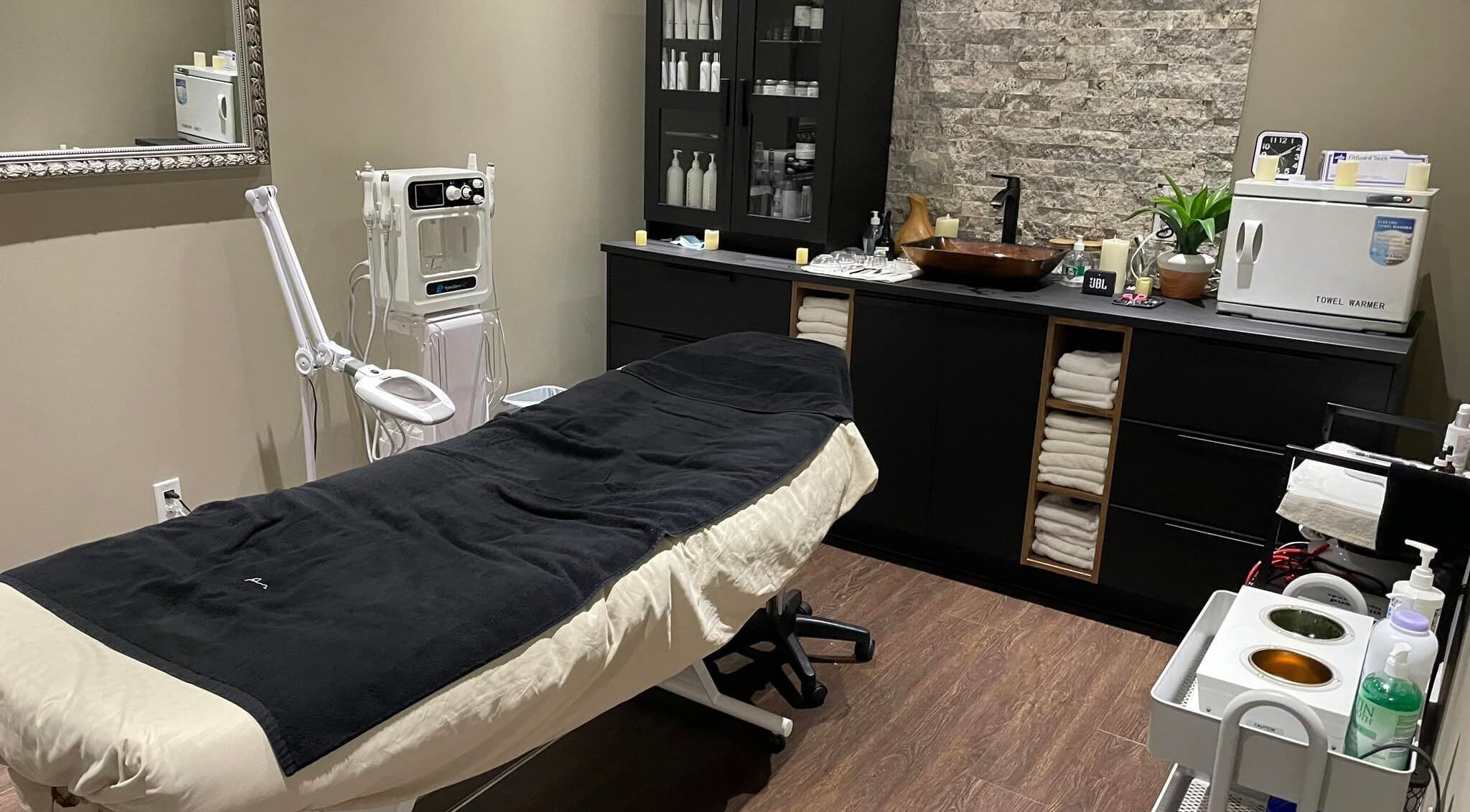 Treatment room at Nurse Cori Injectables & Aesthetics in Milton, Ontario, CA, featuring a massage bed and aesthetic tools.