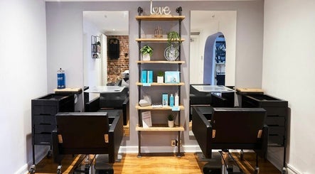Modern salon interior at The Ultimate Touch, Wymondham, England, GB, featuring stylish chairs and shelving decor.