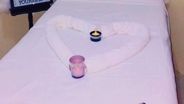 Relaxing massage table setup with towels and candles at Spa D’amour, Oistins, Christ Church, BB.