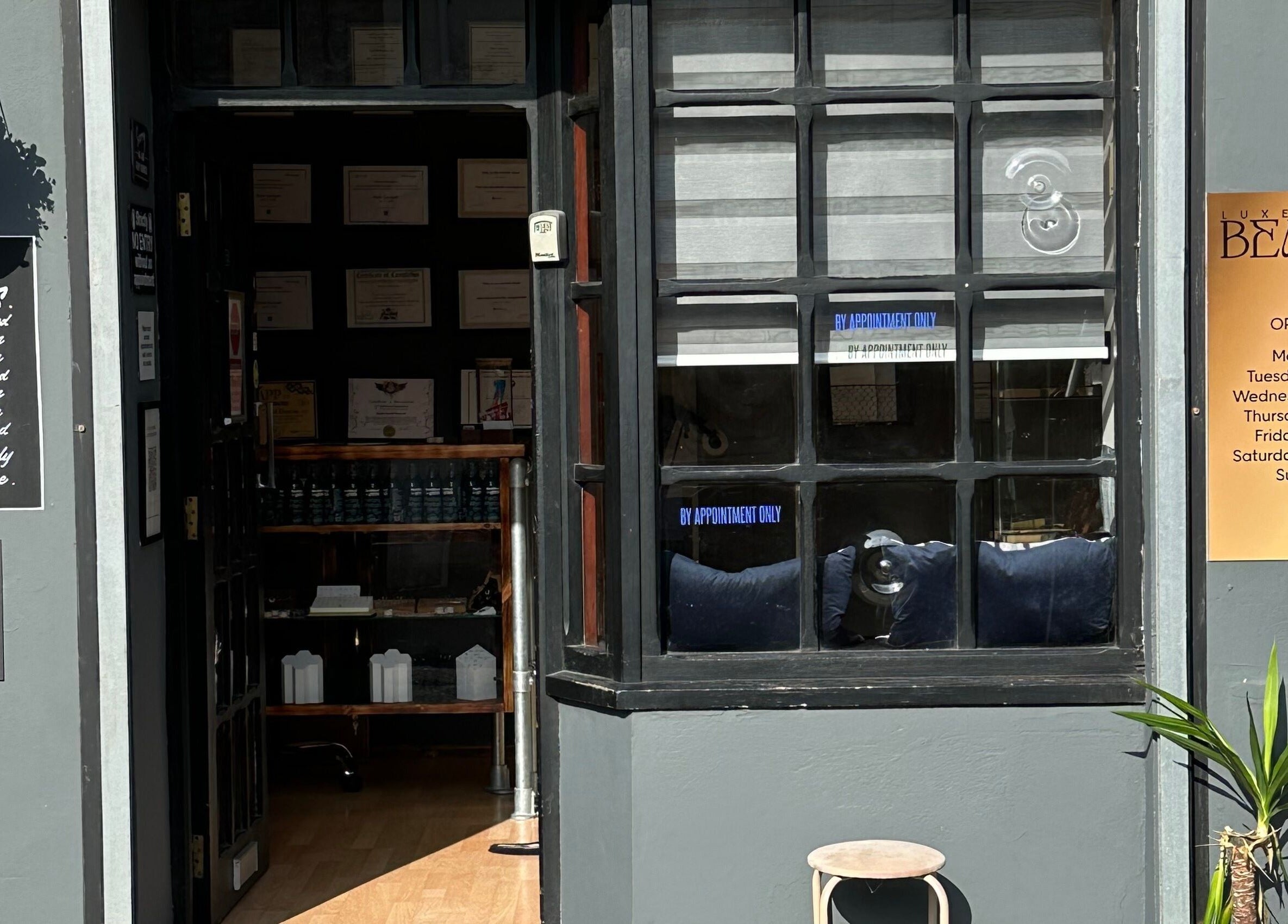 Entrance of The Piercing Co in Bridgend, Wales, GB, featuring opening hours sign and modern decor.