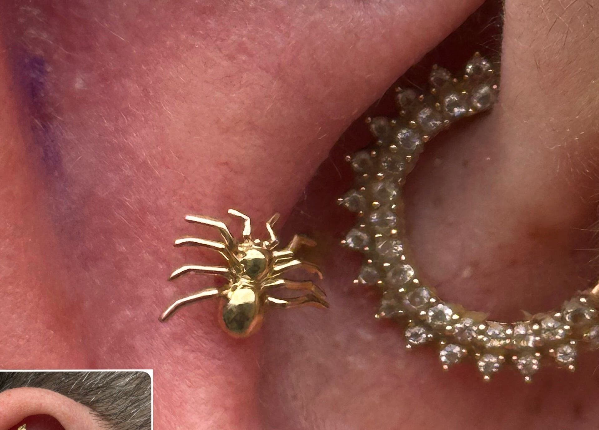 Stylish golden spider earring at The Piercing Co, Bridgend, Wales, GB, paired with a jewel-studded hoop.