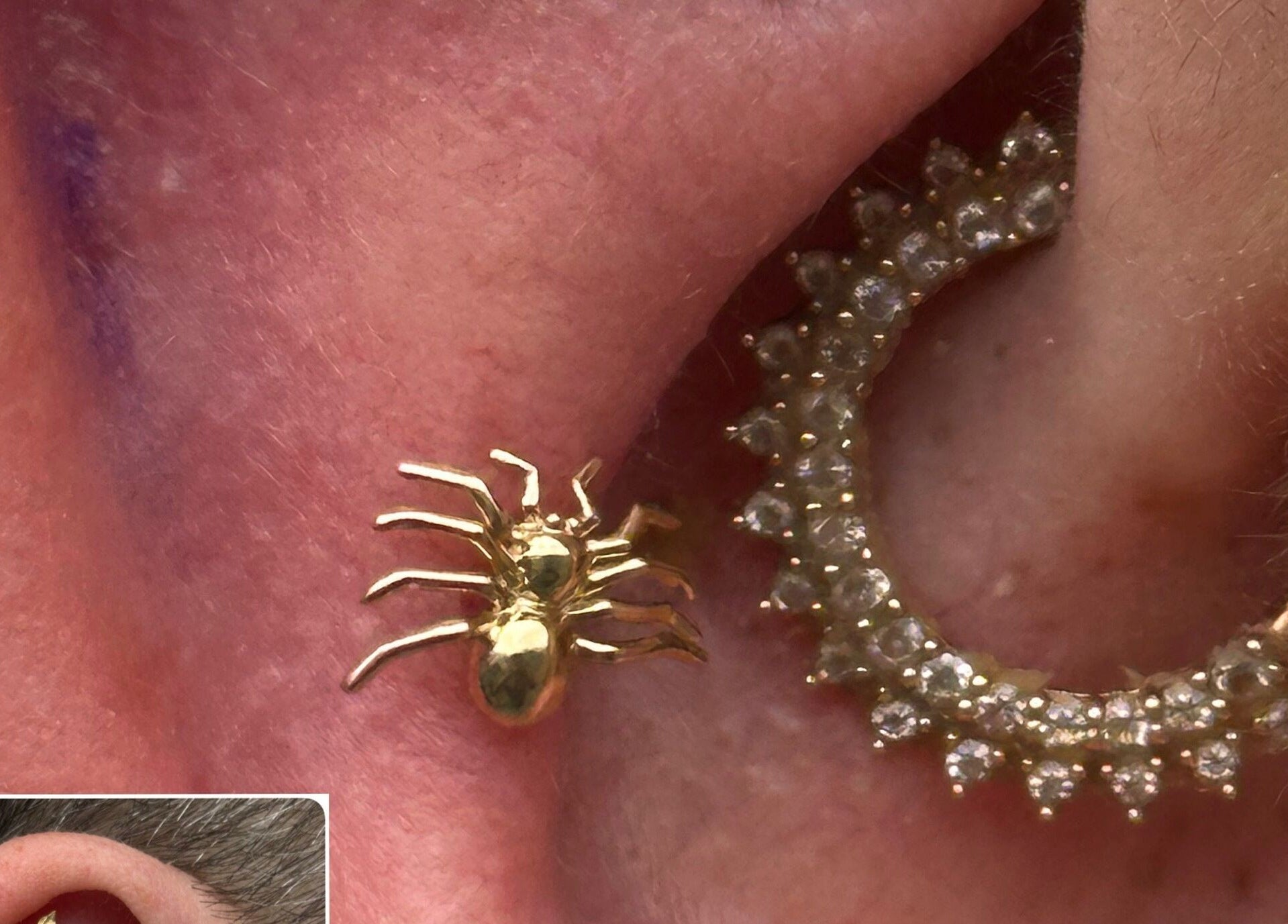 Stylish golden spider earring at The Piercing Co, Bridgend, Wales, GB, paired with a jewel-studded hoop.