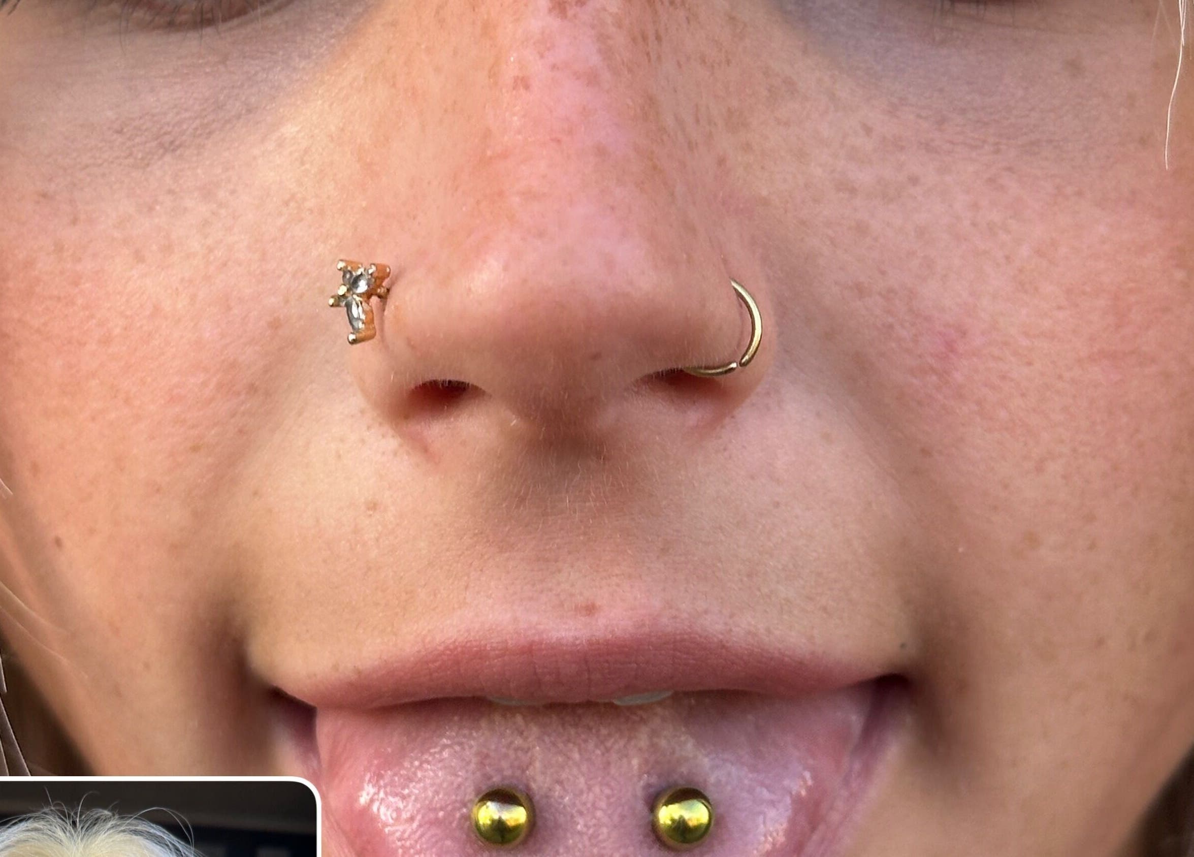 Close-up of elegant facial piercings at The Piercing Co, Bridgend, Wales, GB showcasing unique nose and lip jewelry.