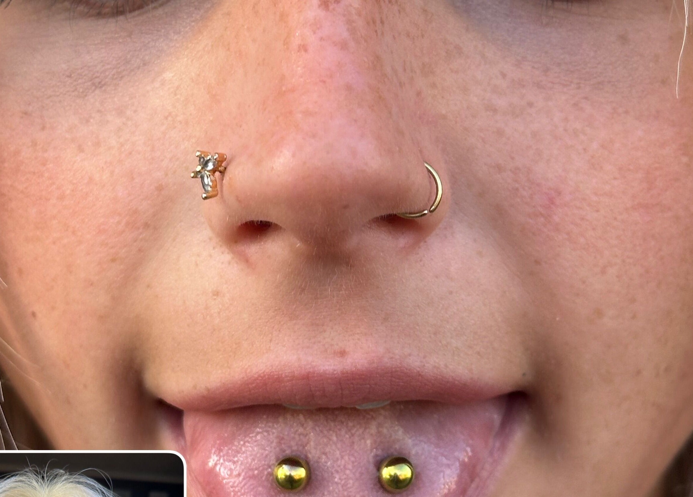 Close-up of elegant facial piercings at The Piercing Co, Bridgend, Wales, GB showcasing unique nose and lip jewelry.