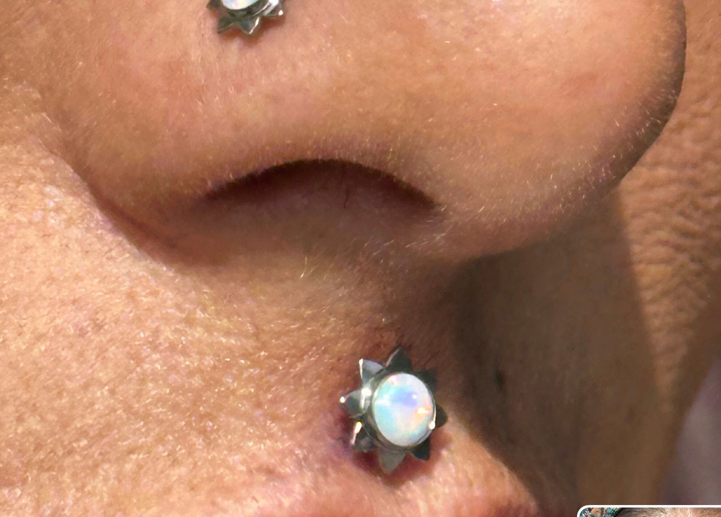 Elegant opal nostril piercing at The Piercing Co, Bridgend, Wales, GB, showcasing expert craftsmanship.