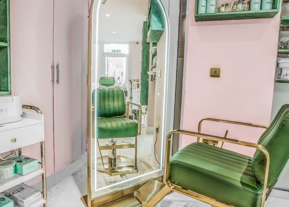 Stylish green chair and illuminated mirror at Beautie.Lab Aesthetics, London, England, GB.