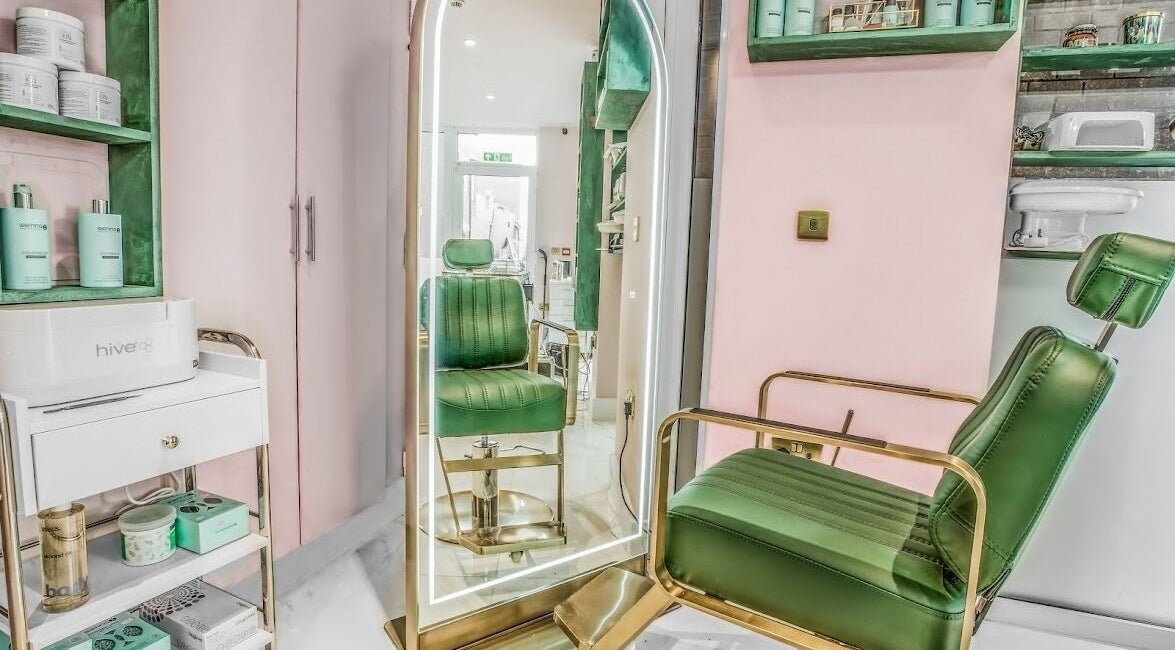 Stylish green chair and illuminated mirror at Beautie.Lab Aesthetics, London, England, GB.