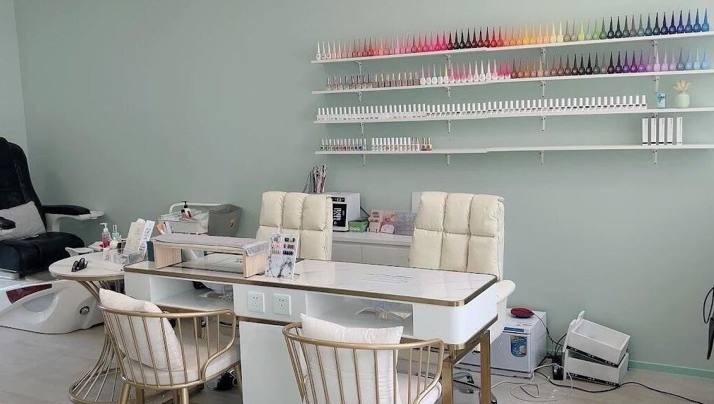 Modern nail salon at Min Beauty, Auckland, NZ, featuring plush chairs and vibrant polish display.