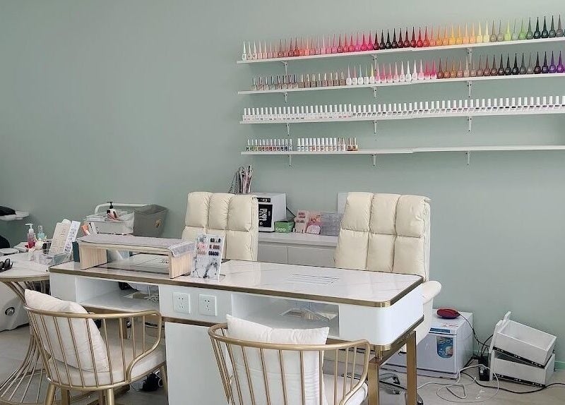 Modern nail salon at Min Beauty, Auckland, NZ, featuring plush chairs and vibrant polish display.