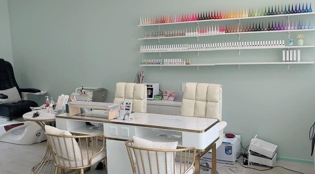 Modern nail salon at Min Beauty, Auckland, NZ, featuring plush chairs and vibrant polish display.