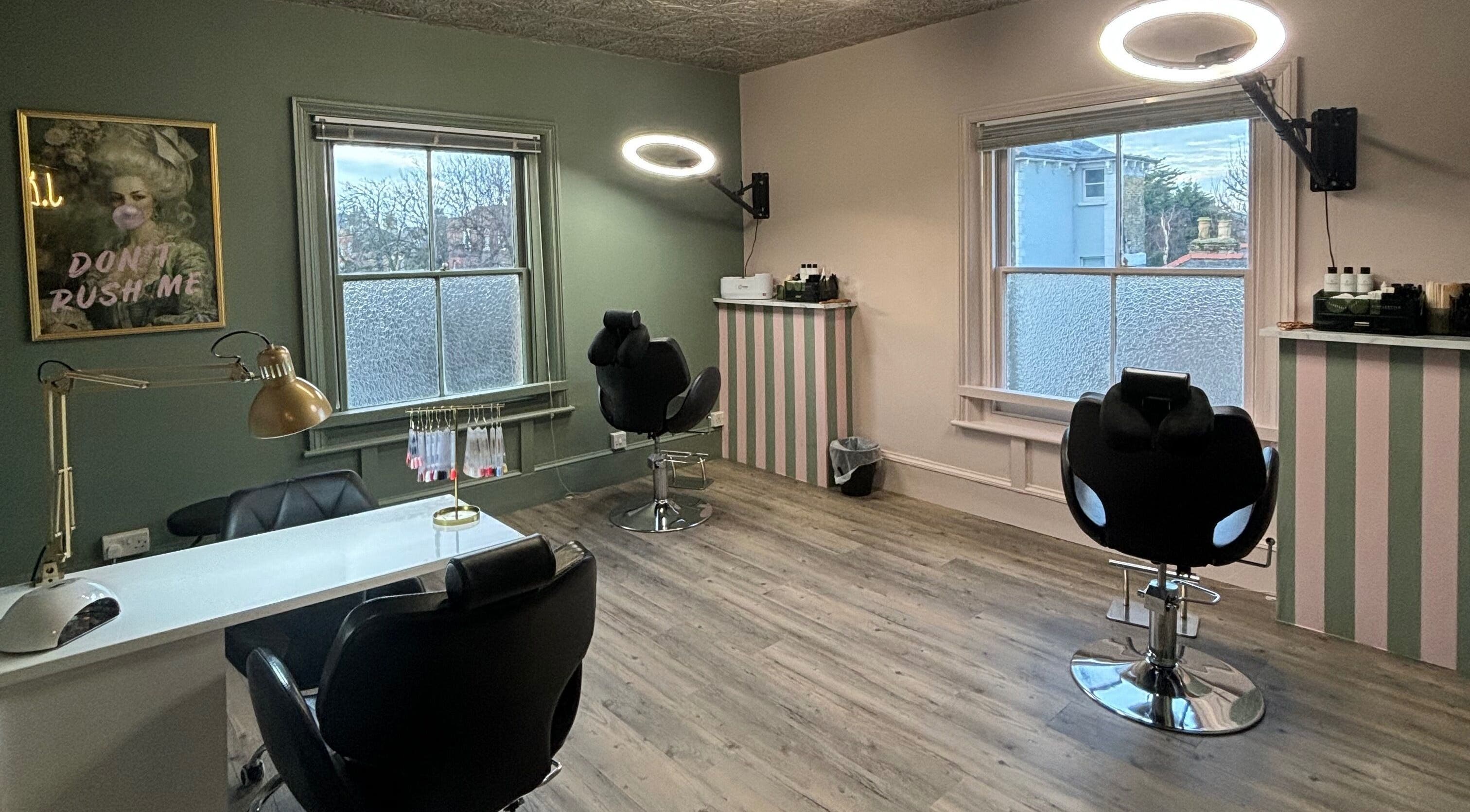 Cozy interior of JLR Brow & Beauty Bar in Deal, England, GB with stylish chairs and natural light.