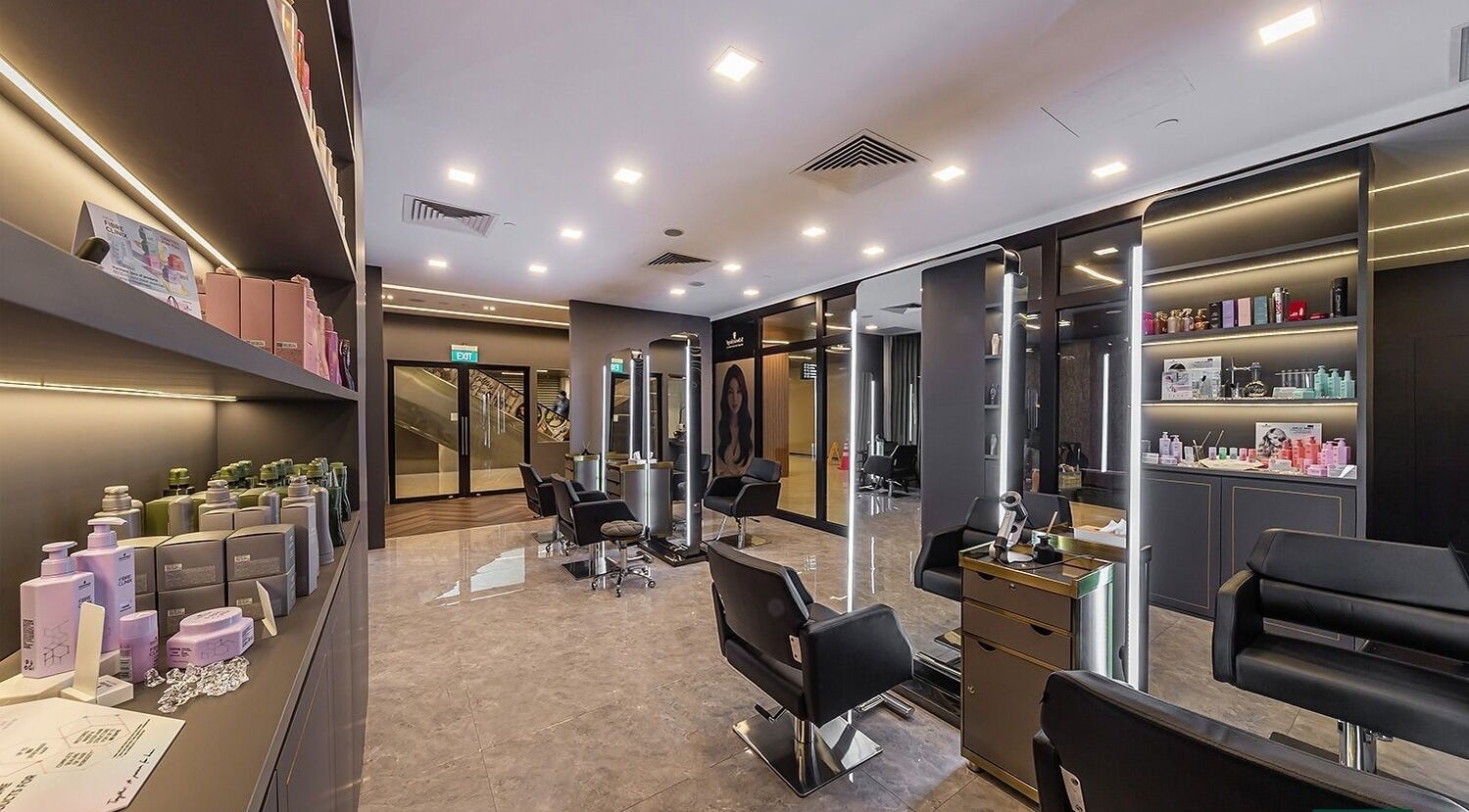 Modern interior of Kiu Hair Gallery, Singapore, SG, featuring sleek styling chairs and products.