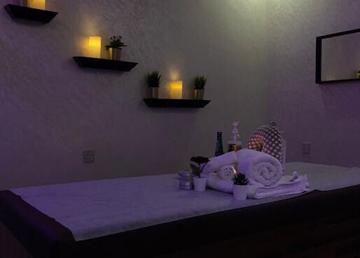 Tranquil massage room at Faisalia Center, Dammam, featuring soft lighting and plush towels.