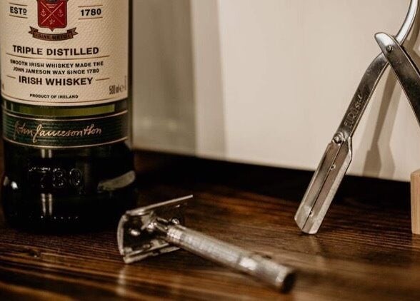 Borotvák és whiskey üveg a Bison Barber Shop Kiskunfélegyháza padlóján, Kiskunfélegyháza, HU.