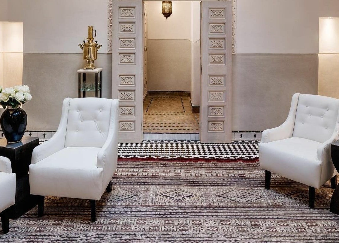 Sophisticated lounge area at Farnatchi Spa, Marrakesh, Marrakesh-Safi, MA featuring white armchairs and ornate decor.