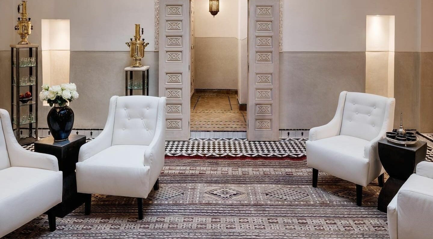 Sophisticated lounge area at Farnatchi Spa, Marrakesh, Marrakesh-Safi, MA featuring white armchairs and ornate decor.