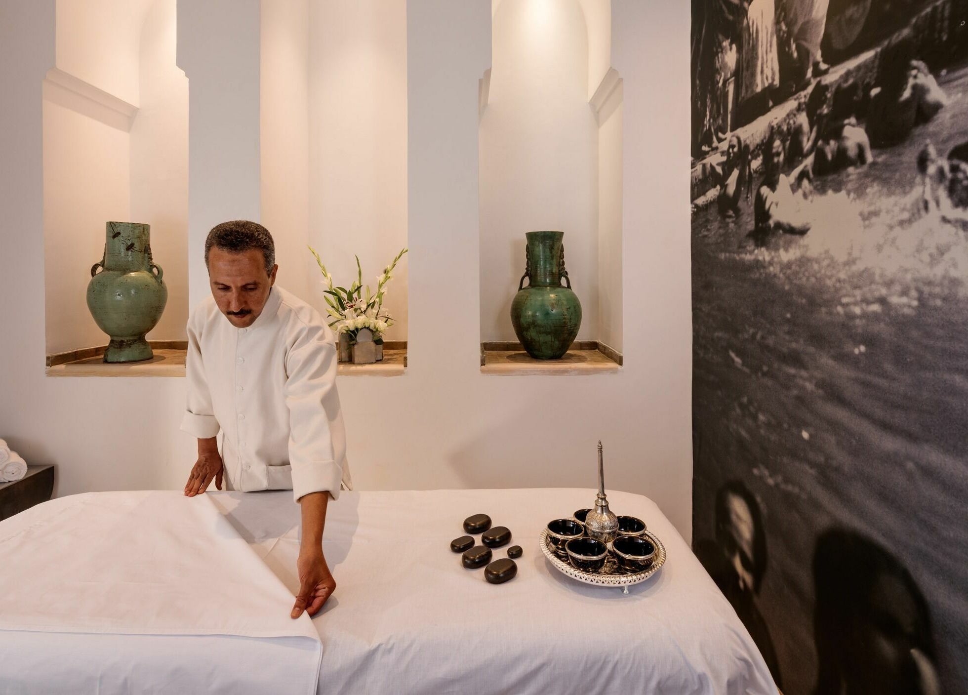 Therapist prepares a treatment room at Farnatchi Spa, Marrakesh, Marrakesh-Safi, MA with elegant decor.