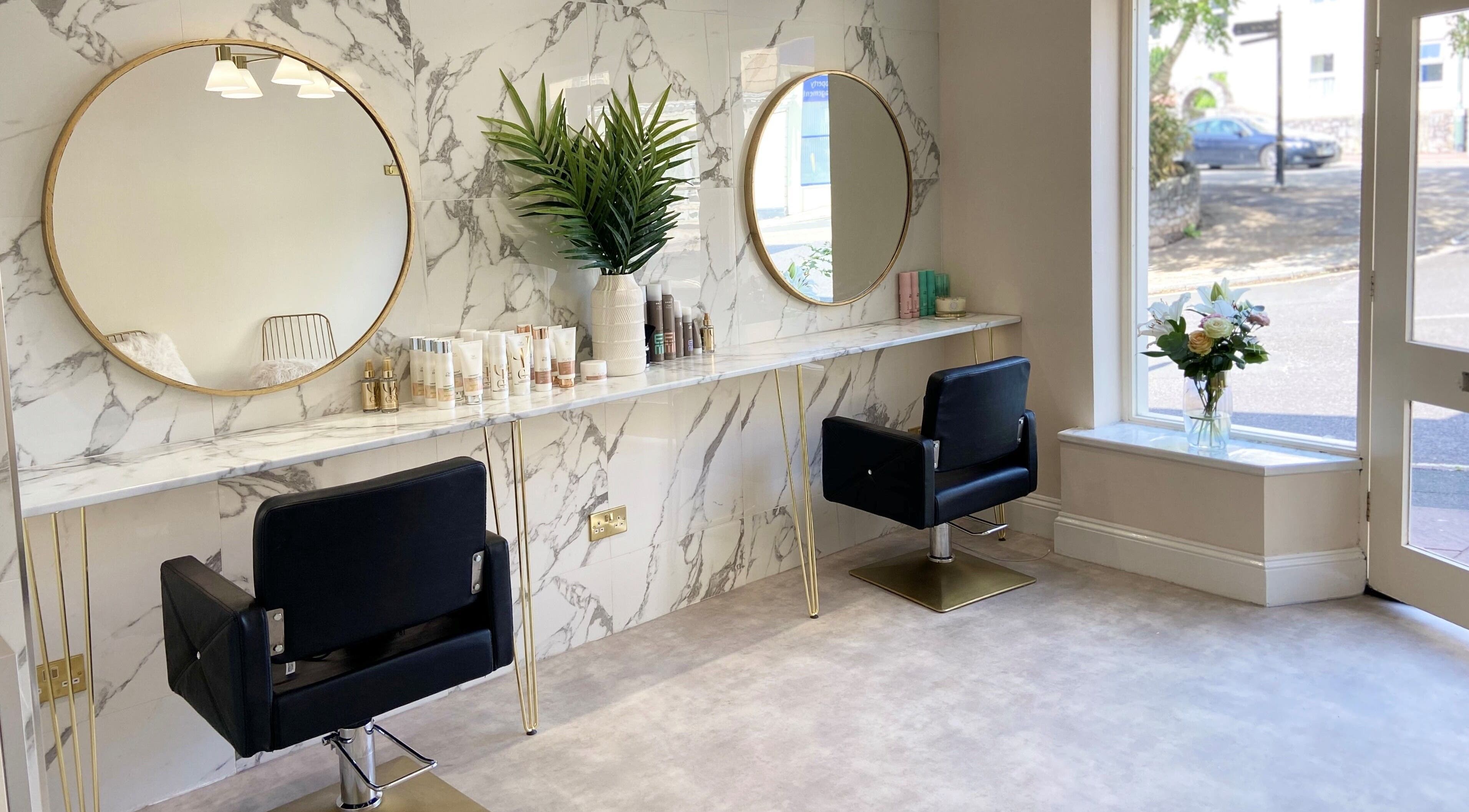 Elegant hair styling area at Fern Hewitt Hair in Devon, England, GB with modern decor and inviting atmosphere.