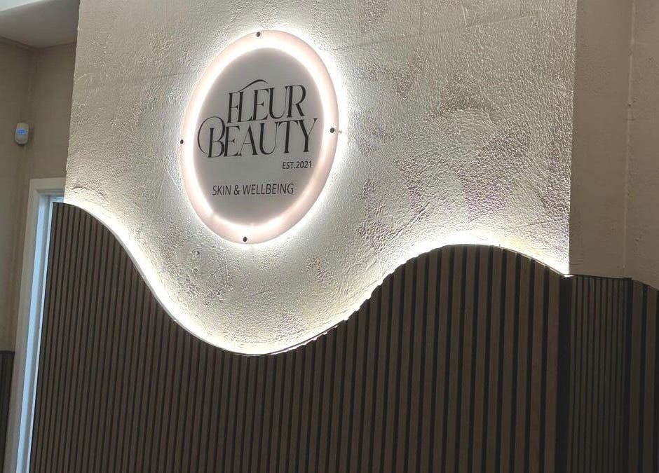 Illuminated sign at Fleur Beauty | Skin and Wellbeing in Barnstaple, England, GB featuring modern interior.