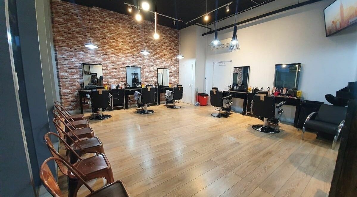 Modern interior of Revival Barbershop Essendon in Melbourne, Victoria, AU with stylish chairs and brick wall.