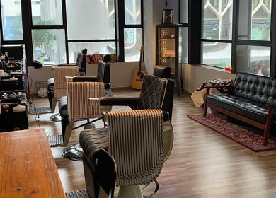Stylish interior of Envy Cuts in Singapore, featuring chic barber chairs and cozy seating area.