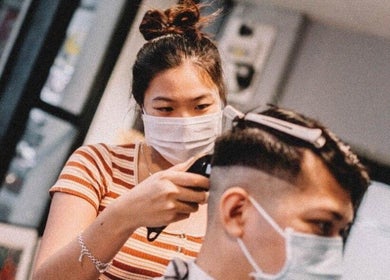 Stylist at Envy Cuts in Singapore, SG, expertly trimming a client's hair with precision clippers.