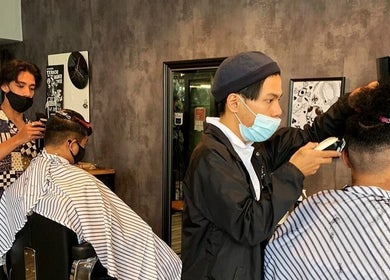 Stylists at Envy Cuts in Singapore, SG expertly grooming clients' hair in a modern salon setting.